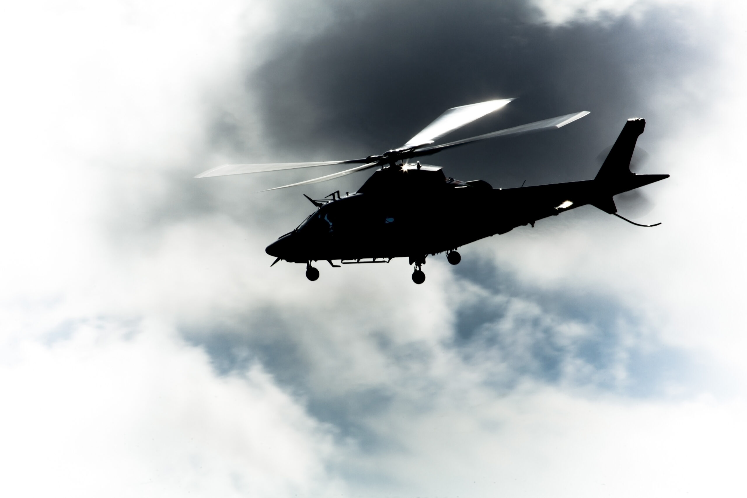 Helikoptera siluets mākoņainās debesīs