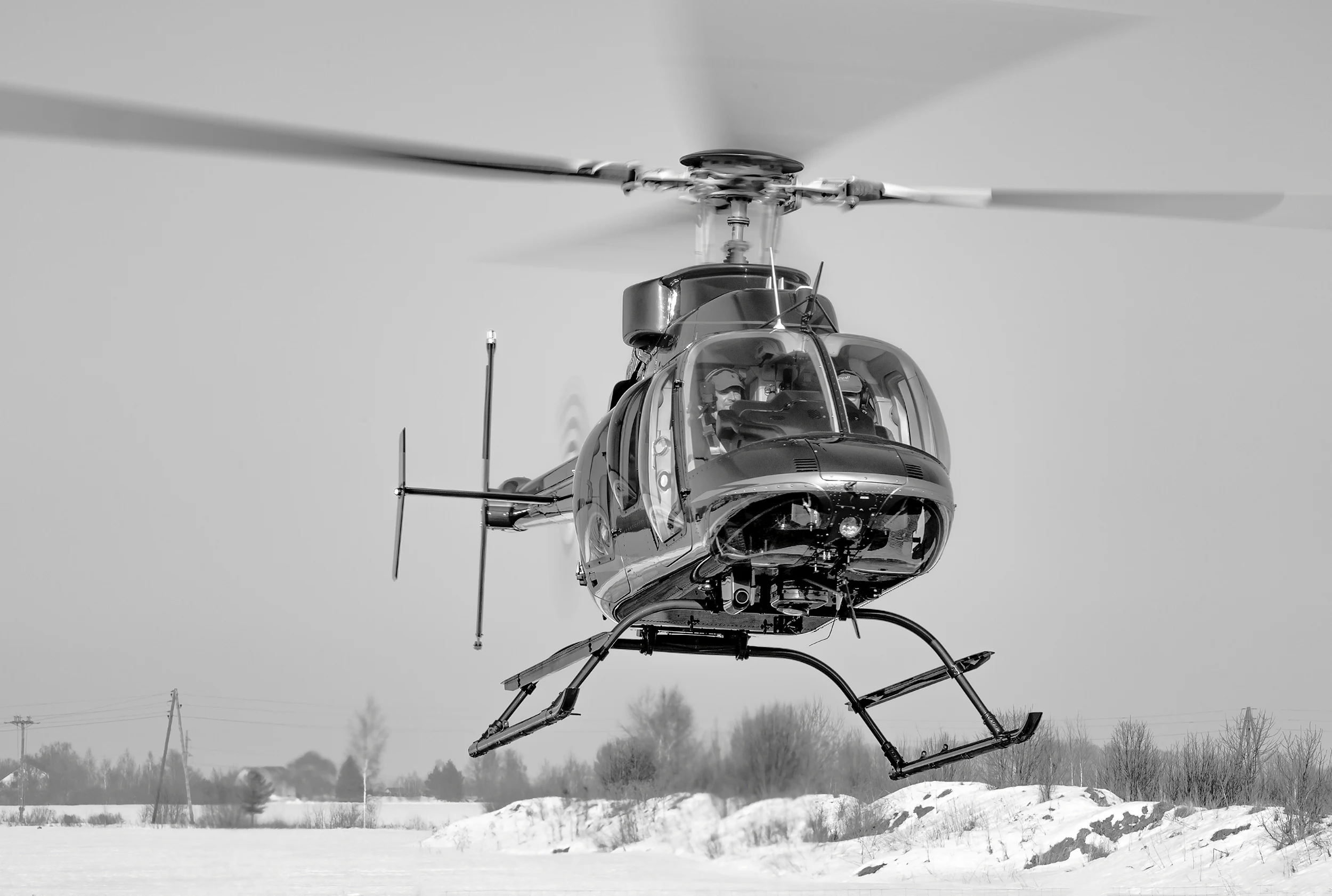 Helikopters virs sniegota lauka